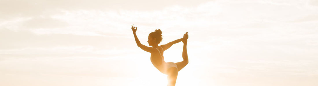 Woman in Yoga pose in front of sunset. 