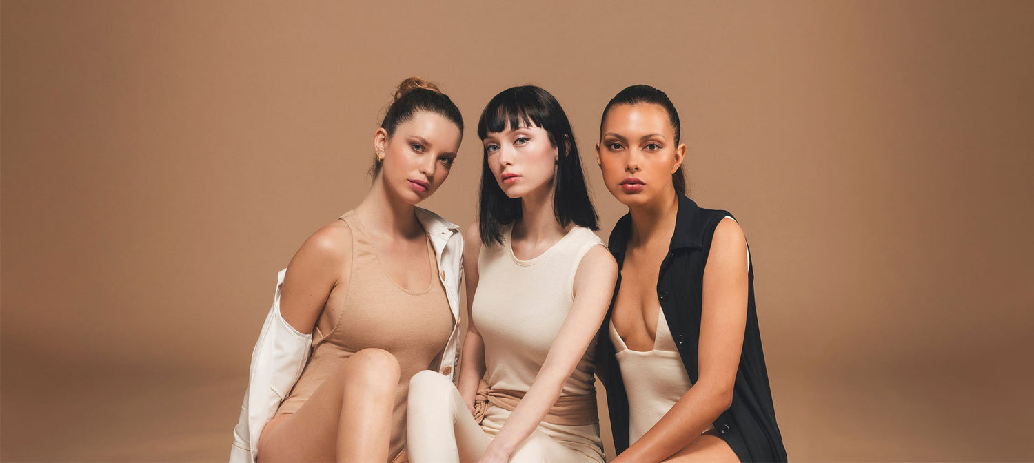 Three models in organic clothing sitting together.