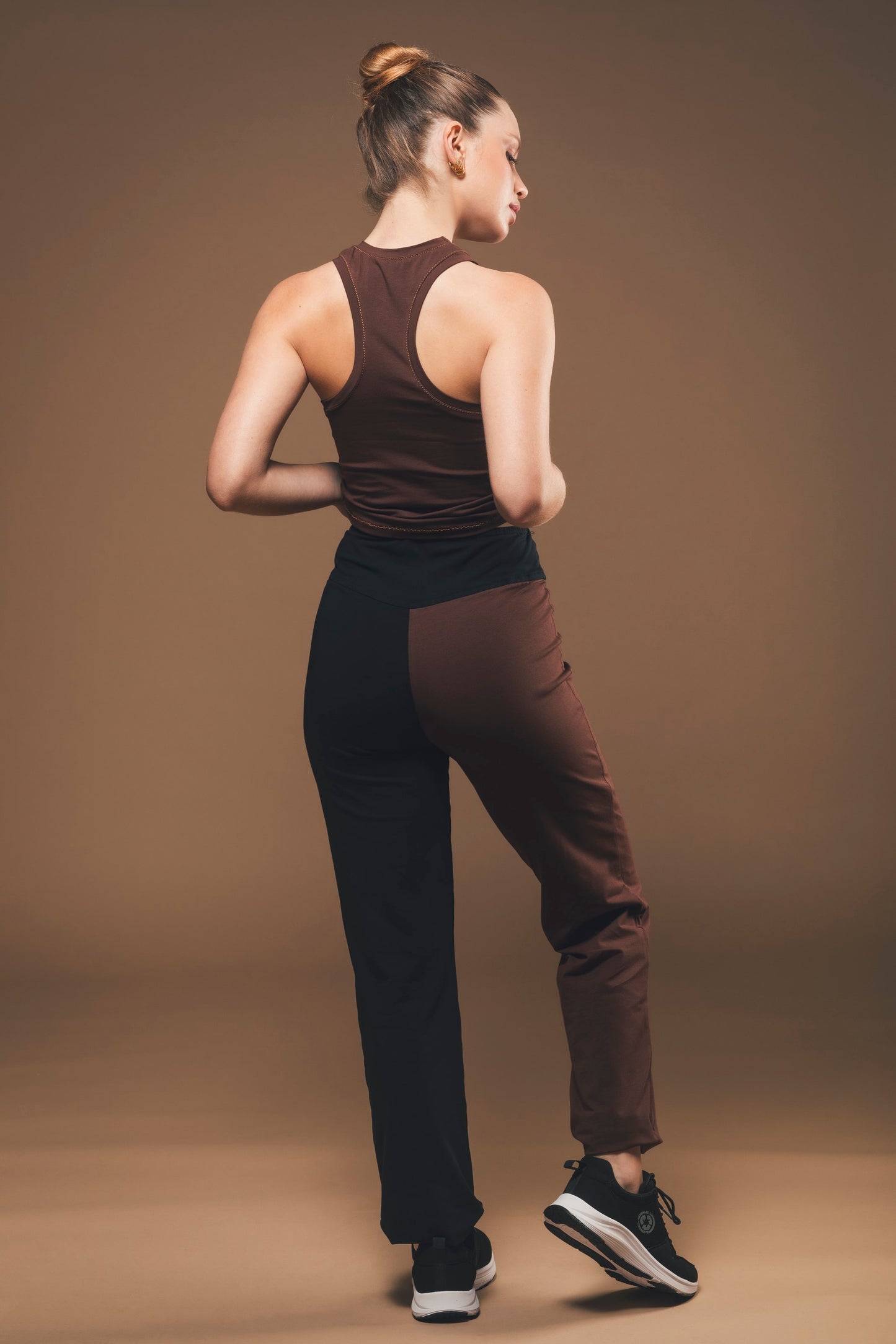Image of back of vegan trousers in black and brown made by Organique, a sustainable clothing brand.