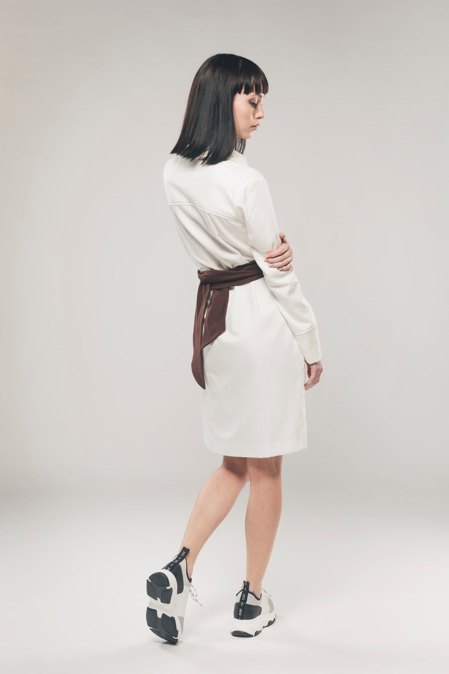 Image of back of white organic cotton shirt dress made by Organique, a sustainable clothing brand.