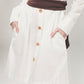 Imagem de detalhe de botão de vestido de camisa branca feita de algodão orgânico pela Organique.
